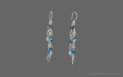 Pair of sterling silver wire wrapped long earrings with Blue Swarovski crystals.
