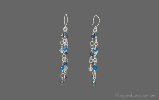 Pair of sterling silver wire wrapped long earrings with Blue Swarovski crystals.